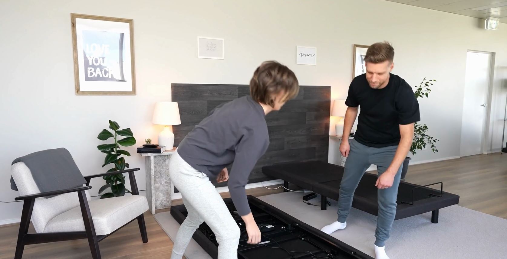A man and a woman assembling an adjustable bed base in a bedroom, a key consideration for how to choose a mattress system for health support.